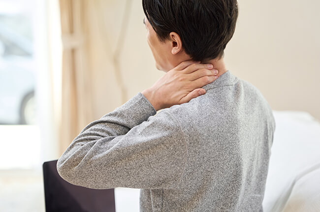 首をおさえる男性